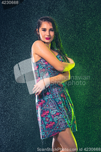 Image of Young beautiful woman under splash of rain