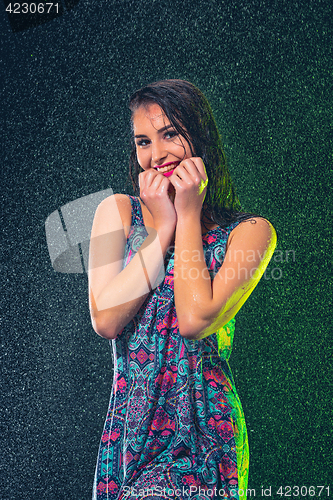 Image of Young beautiful woman under splash of rain