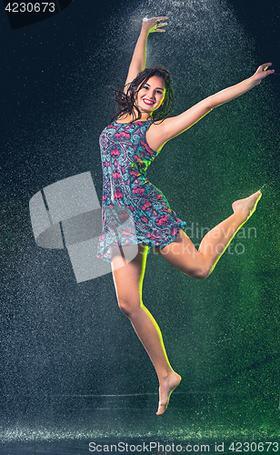 Image of Young beautiful woman under splash of rain