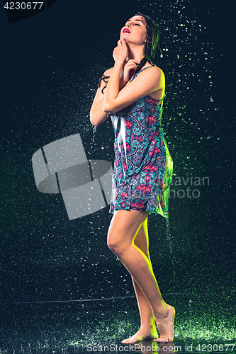 Image of Young beautiful woman under splash of rain