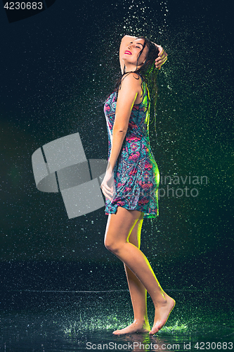 Image of Young beautiful woman under splash of rain