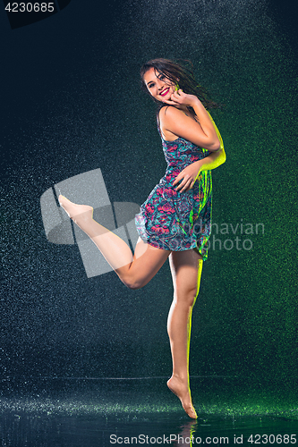 Image of Young beautiful woman under splash of rain