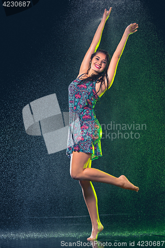 Image of Young beautiful woman under splash of rain