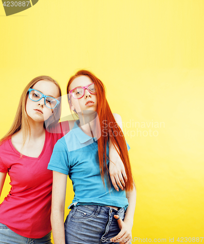 Image of lifestyle people concept: two pretty young school teenage girls having fun happy smiling on yellow background