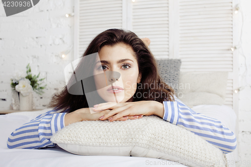 Image of young pretty brunette woman in her bedroom sitting at window, happy smiling lifestyle people concept 