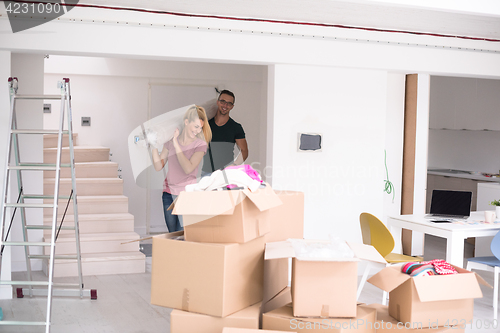 Image of couple carrying a carpet moving in to new home