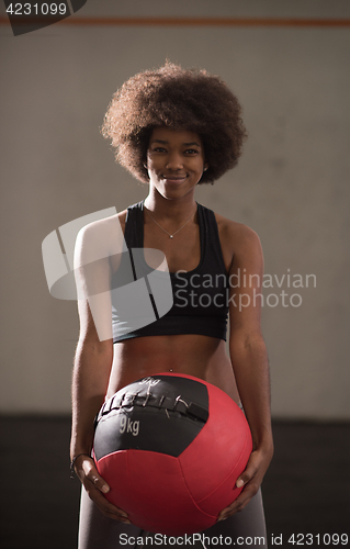 Image of black woman carrying crossfit ball