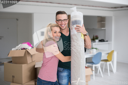 Image of couple carrying a carpet moving in to new home