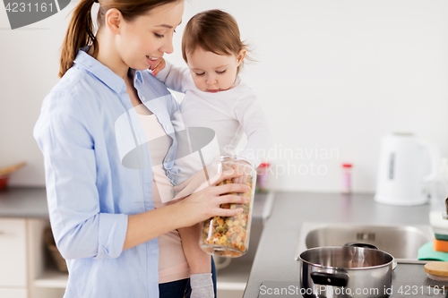 Image of mother and baby cooking pasta at home kitchen