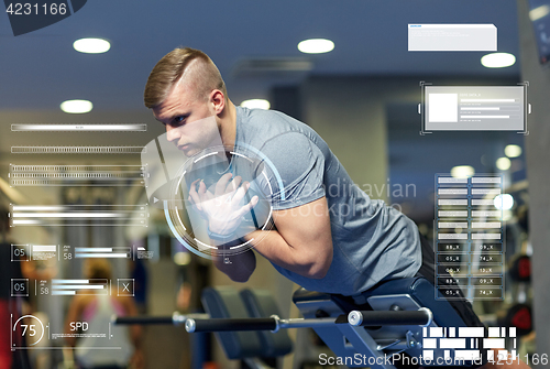 Image of young man flexing back muscles on bench in gym