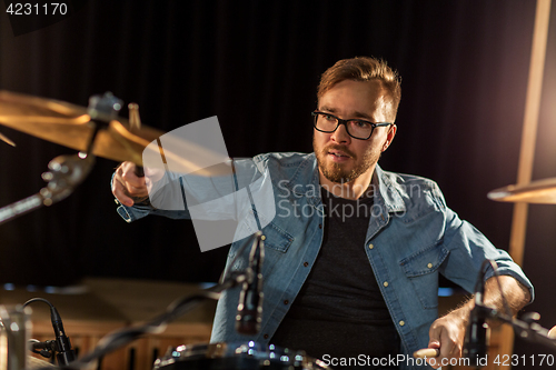 Image of male musician playing drums and cymbals at concert