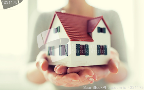 Image of close up of hands holding house or home model