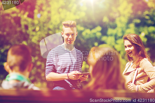 Image of group of teenage students with tablet pc outoors