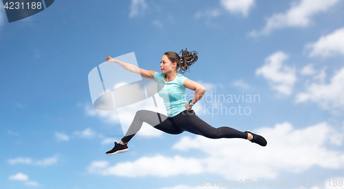 Image of happy sporty young woman jumping in fighting pose