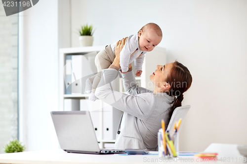 Image of happy businesswoman with baby and laptop at office