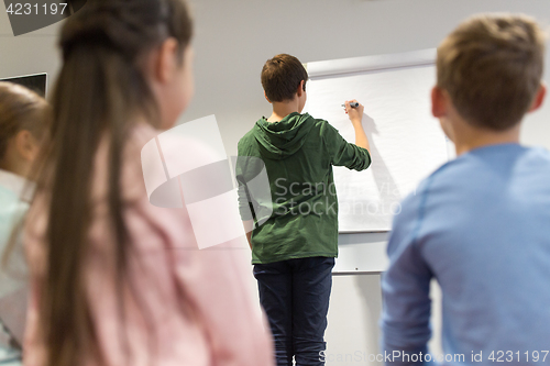 Image of student boy with marker writing on flip board