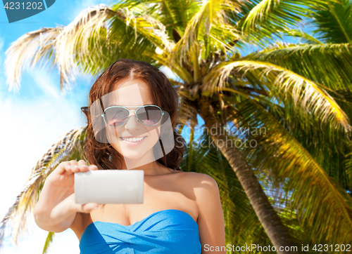 Image of woman in swimsuit taking selfie with smatphone