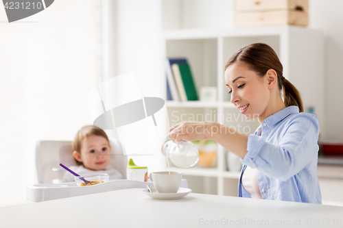 Image of happy mother and baby having breakfast at home