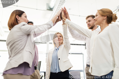 Image of happy business team making high five at office