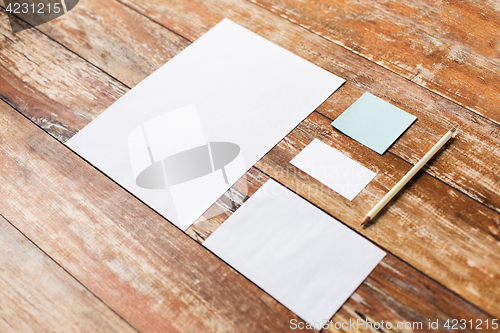 Image of blank paper sheets and pencil on wooden board