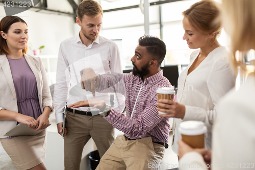 Image of happy business team drinking coffee at office