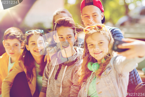 Image of happy teenage students taking selfie by smartphone