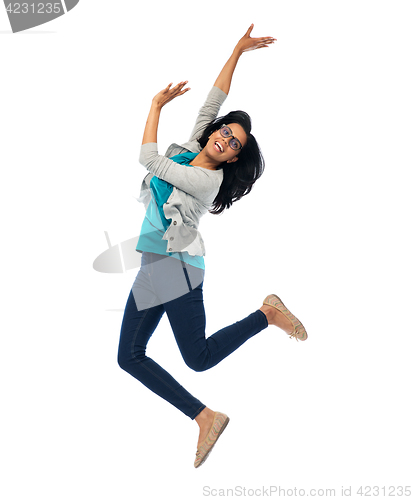 Image of smiling young indian woman jumping in air