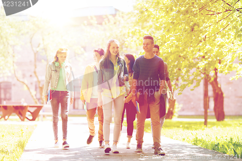 Image of group of happy teenage students walking outdoors