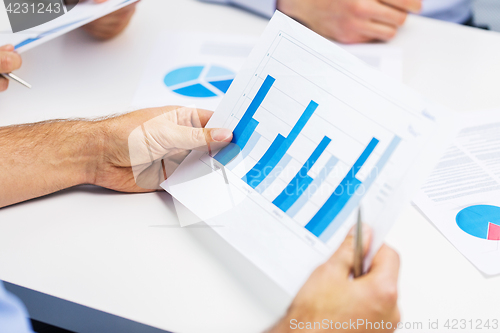 Image of male hands holding paper with charts at office