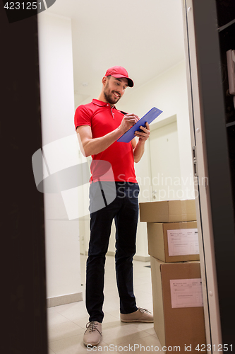 Image of delivery man with boxes and clipboard at door