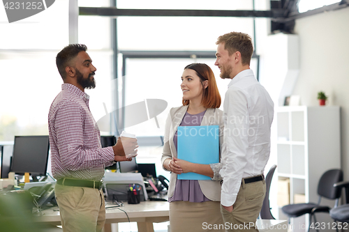 Image of happy business team drinking coffee at office