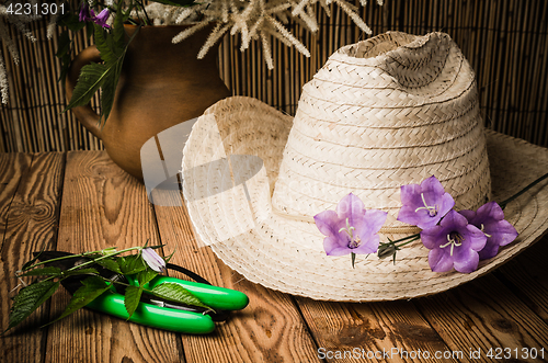 Image of Straw hat and flowering campanula, close-up