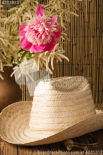 Image of Straw hat and peony flower, close-up