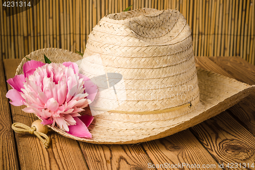 Image of Straw hat and peony flower, close-up