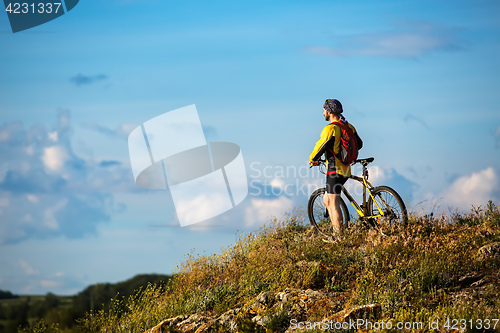 Image of Young man cycling on a rural road