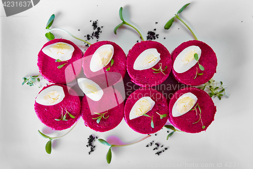 Image of layered salad with herring, beets, carrots, onions, potatoes and eggs close-up on a plate. horizontal.
