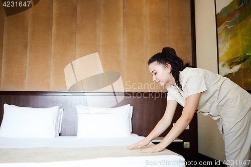 Image of Hotel service. Made making bed in room.