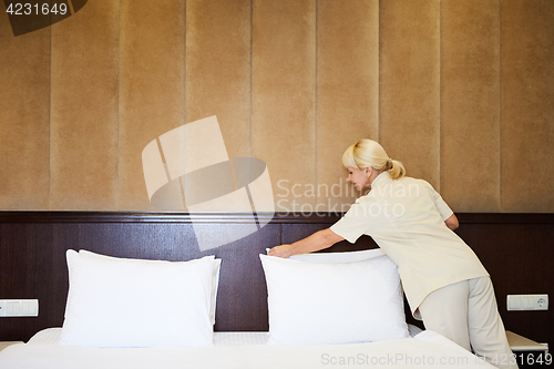 Image of Hotel service. Made making bed in room.