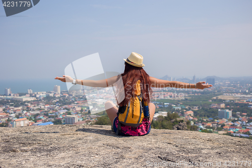Image of Girl sits back on hill