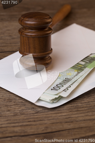 Image of Wooden table with hammer, banknotes