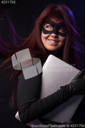 Image of Thief in mask holds laptop