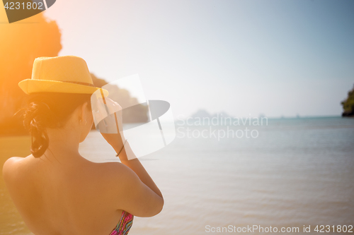 Image of Brunette in hat on sea