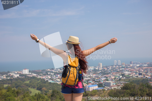 Image of Brunette stands with arms raised