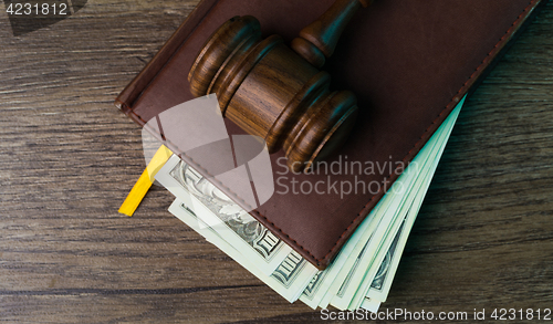 Image of Judge\'s hammer, folder with dollars