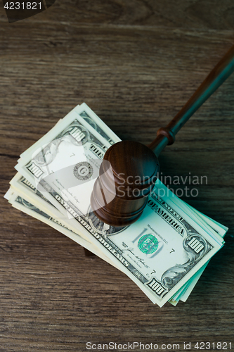 Image of Judge\'s hammer lies on dollars