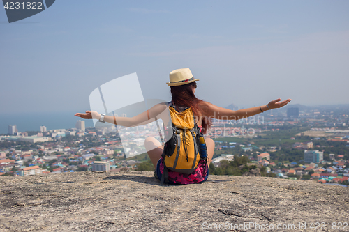 Image of Woman sitting back on hill