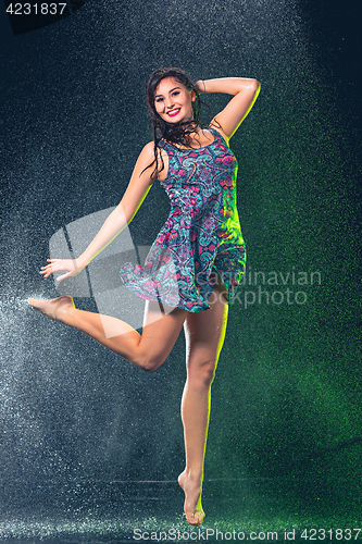 Image of Young beautiful woman under splash of rain