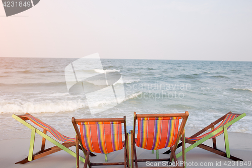 Image of Two deck chairs on beach