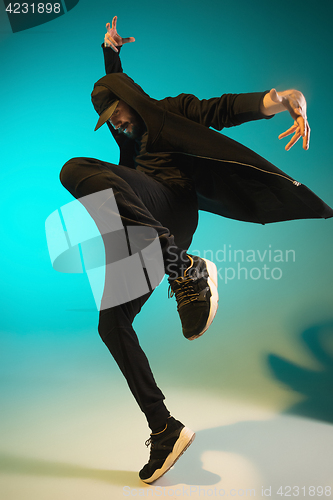 Image of The silhouette of one hip hop male break dancer dancing on colorful background