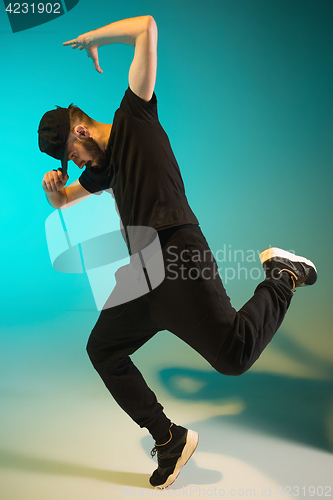 Image of The silhouette of one hip hop male break dancer dancing on colorful background